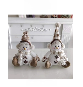 Vue avant de deux bonhommes de neige de Noël avec bonnets en tricot et écharpes rayées