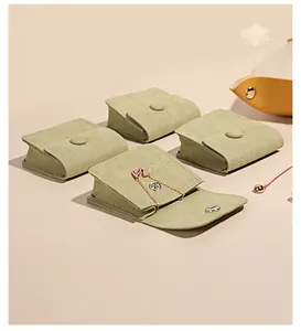 Sage green microfiber jewelry pouches with rose gold necklace on a display card