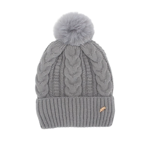 Détail du bonnet en tricot gris avec pompon en fourrure et emblème de blé doré