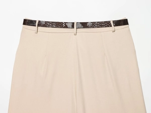 Détail d'un short beige à taille haute avec une ceinture à motif peau de serpent marron
