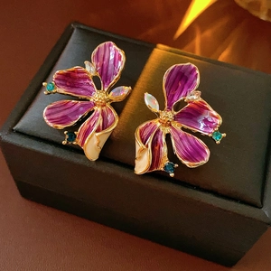 Nahaufnahme der Vintage-Blumenohrringe mit lila Emaille und Kristallen in einer Geschenkbox