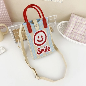 Detail of knit mini crossbody bag with red smile face and colorful vertical stripes