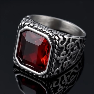 Macro shot of men's vintage silver steel ring with red square gemstone and ornate carving