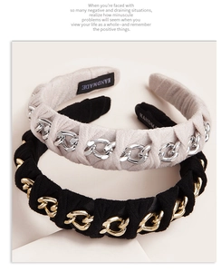 Detail showing handmade chain-wrapped suede headbands in beige and black fabric texture