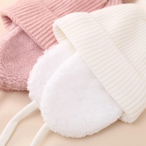 Détail de la doublure en polaire douce et bonnets tricotés pour enfants