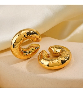 Detail of 18K gold-plated stainless steel clip-on earrings with hammered texture on silk
