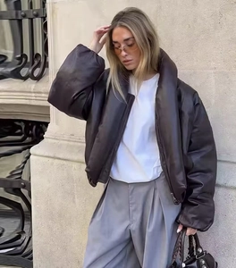 Dettaglio di una giacca corta in ecopelle marrone scuro con collo alto e cerniera