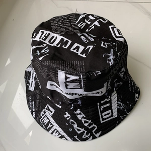 Detail of black canvas bucket hat featuring a vintage white newspaper print design