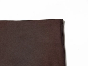 Close-up of deep brown twill fabric showing detailed stitching and textile texture