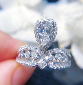 Macro shot of a pear-cut cubic zirconia ring with an intricate V-shaped hollow silver band