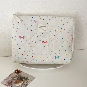 Close-up of quilted cotton makeup bag with colorful polka dots and bow patterns