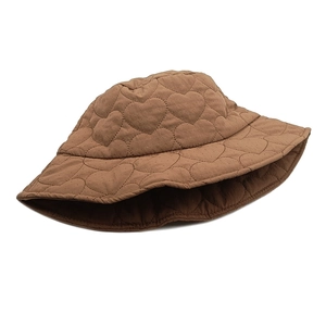 Close-up of heart quilted texture on warm brown winter bucket hat with fine stitching