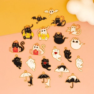 Close-up of 18 styles of black and white cat alloy charms for Halloween jewelry making