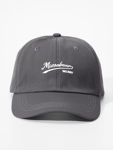 Close-up of white Mizoobean embroidery on dark grey cotton twill baseball cap