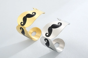 Macro detail of mustache-shaped metal bracelets in polished gold and silver finishes