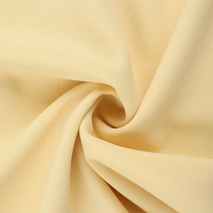 Macro shot of yellow halter dress fabric showing soft grainy texture and drape