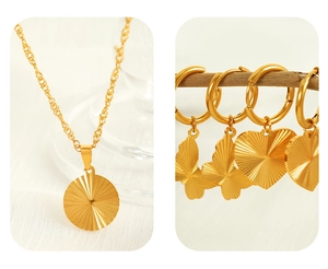 Detail of 18K gold plated stainless steel necklaces and butterfly heart earrings on wood