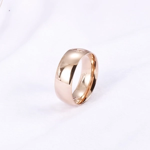 Detailansicht eines polierten Edelstahlrings in Roségold auf weißem Strickgewebe