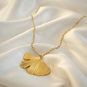 Elegant 18K gold ginkgo leaf pendant necklace on white silk background with O-chain link