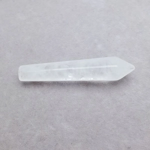 Macro detail of natural clear hexagonal crystal point showing smooth polished texture