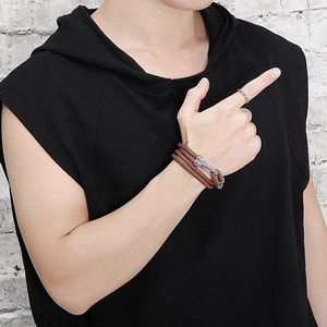 Detail of multi-layer brown braided leather bracelet with silver buckle on male wrist