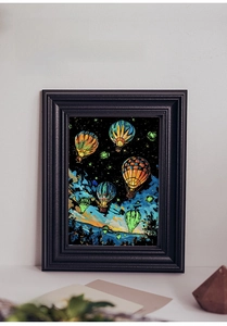 Art à gratter A4 lumineux montrant des montgolfières colorées dans un ciel étoilé nocturne