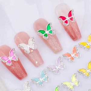 Close-up of colorful 3D butterfly nail charms with rhinestones on sparkling nails