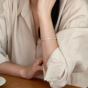 Close-up of a 3mm minimalist S925 silver bangle paired with a matching ring on a model