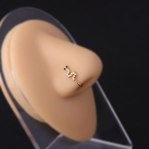 Detail of a gold snake faux nose ring with zircon stones on a silicone model