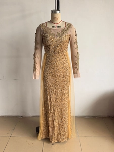 Détail de robe dorée à paillettes avec broderies florales 3D et décolleté en tulle