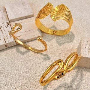 Three gold stainless steel bangles with textured wing and minimalist wave design