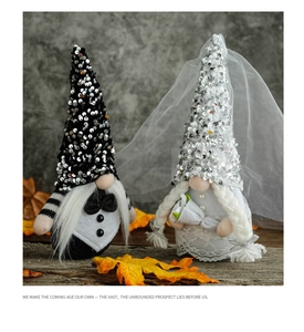 Close-up of bridal gnome with white lace veil and groom gnome with black bowtie decor