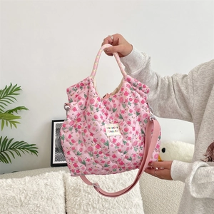 Sac à main matelassé rose à motif de tulipes montrant la bandoulière et la texture douce