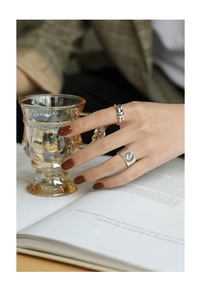 Detail of vintage S925 silver coins rings with portrait relief and woven twist band