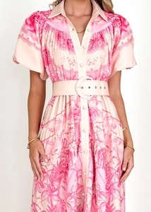 Close-up of pink floral top with ruffle stand collar and wide round buckle belt