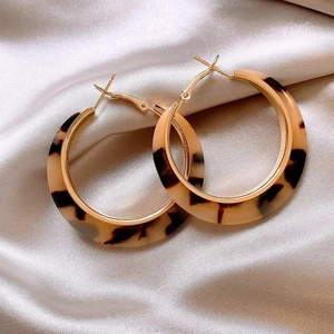Retro round leopard print resin earrings with gold accents on silver satin fabric