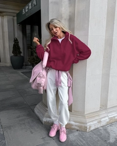 Street style shot of a burgundy half-zip fleece sweatshirt for women on a city street