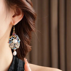 Detail of vintage enamel flower earring with pearls on model's ear in warm natural light