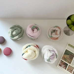 Close-up of five pairs of thick coral fleece warm socks in various cute cartoon patterns