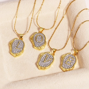Close-up of four gold-plated necklaces forming LOVE with zircon-inlaid pendants