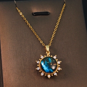 Macro view of golden planet pendant with blue nebula center and sparkling rhinestones