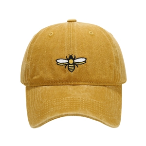 Close-up of high-quality bee embroidery on a vintage yellow washed cotton baseball cap