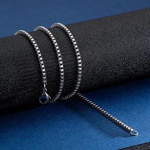 Classic silver stainless steel box chain necklace with lobster clasp on dark pedestal