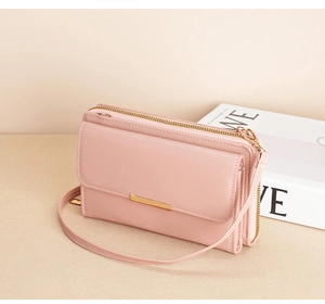 Detail view of pink leather crossbody phone bag with multi-layer zipper compartments