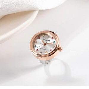 Macro detail of rose gold ring watch featuring colorful crystal indices and silver dial