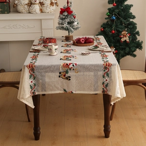 Detail of Christmas tablecloth showing embroidered reindeer and Santa on beige fabric