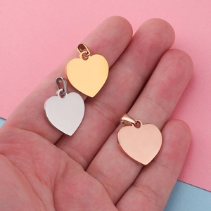 Polished heart pendants in gold, silver, and rose gold finishes held in hand