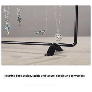 Close-up of iron necklace display stand featuring celestial pendants with a rotating base