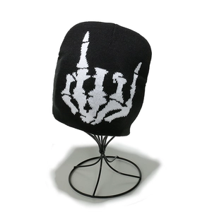 Close-up of a black knit beanie featuring a white skeleton hand middle finger pattern