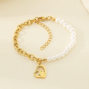 Detail of heart pendant with family engraving and pearls on a gold chain bracelet